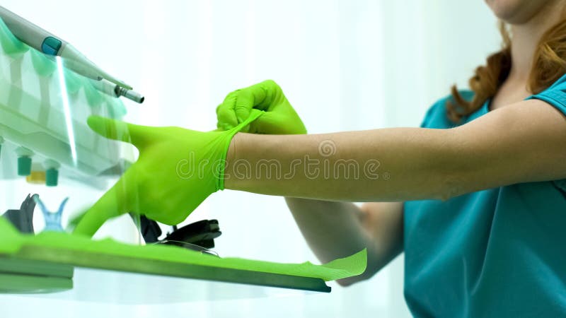 Dametandarts die medische handschoenen aanzetten, modern materiaal, hoogte - de kwaliteitsdienst royalty-vrije stock afbeeldingen Dametandarts die medische handschoenen aanzetten, modern materiaal, hoogte - de kwaliteitsdienst royalty-vrije stock afbeeldingen
