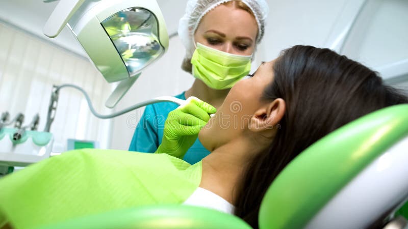 Dametandarts die vrouwelijke geduldige tand, gezondheid genezen van mondholte, moderne kliniek stock fotografie Dametandarts die vrouwelijke geduldige tand, gezondheid genezen van mondholte, moderne kliniek stock fotografie