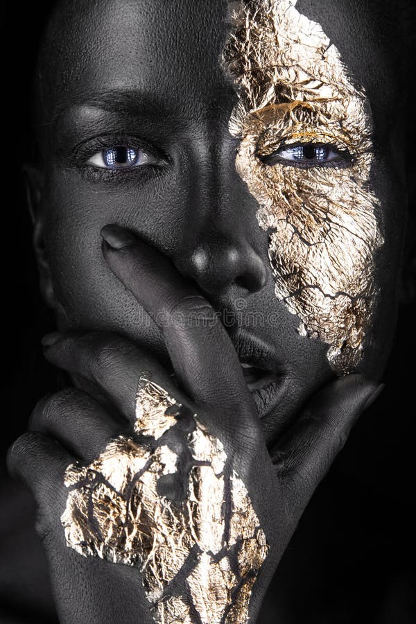 Dana ståenden av en mörkhyad flicka med guld royaltyfri bild
