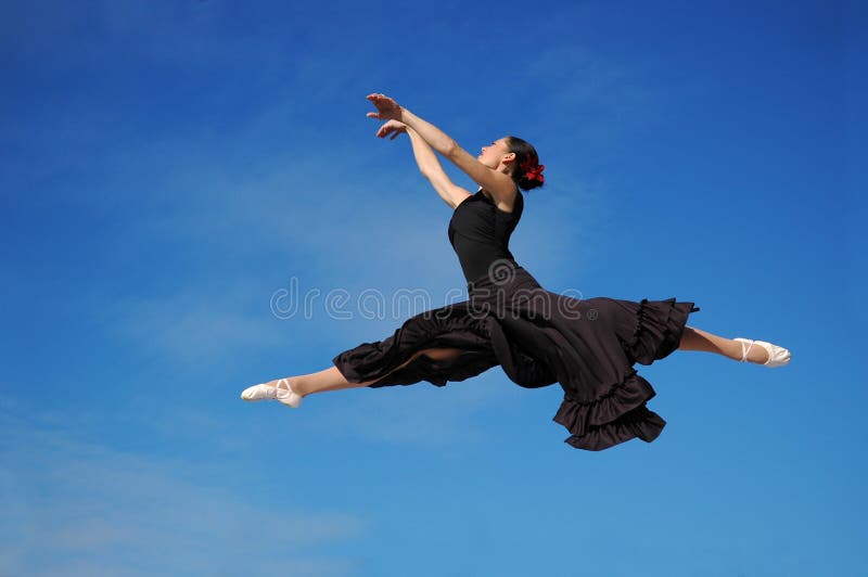 Dancer jumping against blue sk