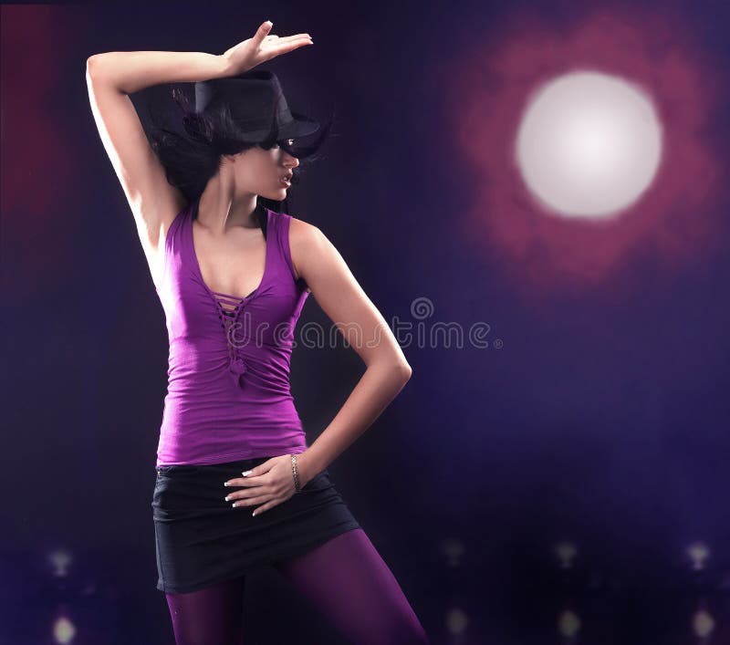 Dancing girl wearing a hat over abstract background. Disco violet light stock images, royalty-free photos and pictures