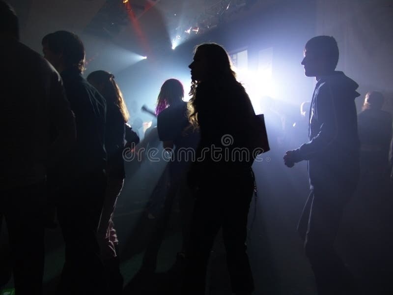 Silhouettes of dancing people in a disco. Disco violet light stock images, royalty-free photos and pictures