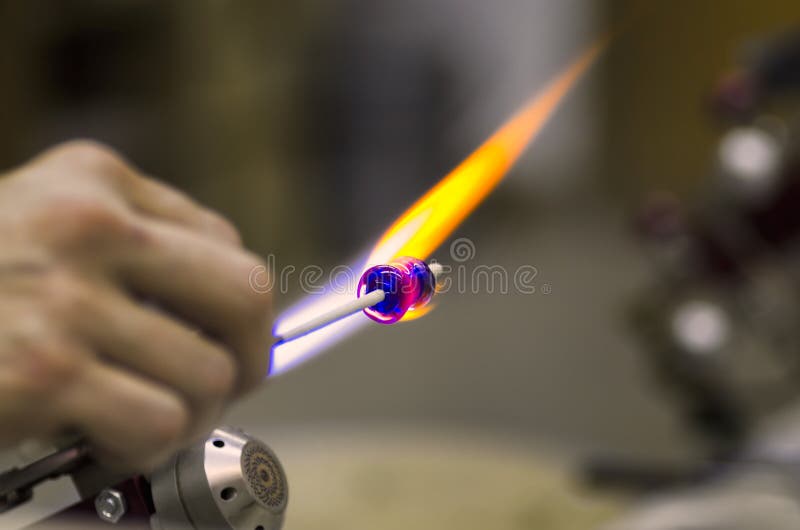 Glass artist using a propane torch to shape colorful glass. Glass artist using a propane torch to shape colorful glass