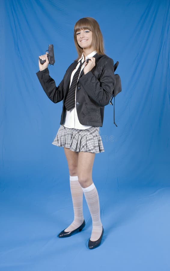 Danger school girl Beautiful young girl with the pistol in a hands on blue background