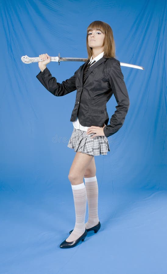 Beautiful girl in a skirt with the Japanese sword on blue background. Beautiful girl in a skirt with the Japanese sword on blue background
