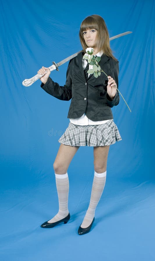 Beautiful girl in a skirt with the Japanese sword on blue background. Beautiful girl in a skirt with the Japanese sword on blue background