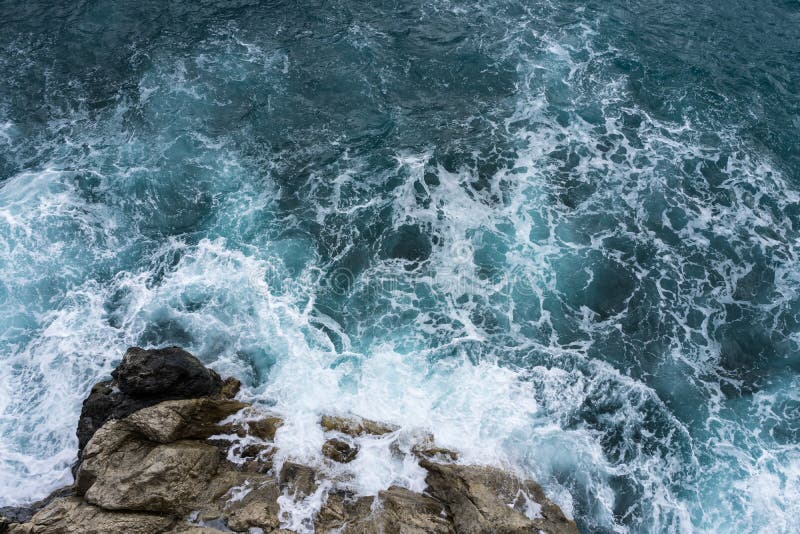 Danger sea wave crashing on rock coast with spray and foam before storm in Autum Positano, Italy