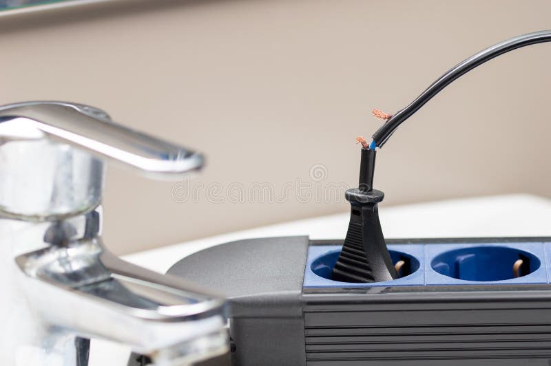 Close up of a dangerous damaged electrical cord a tabletop at bathroom. Damaged extension cord stock images, royalty-free photos and pictures