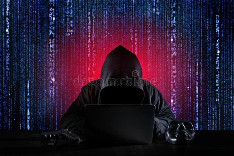 Dangerous hacker man in black hooded, masked and gun using computer, breaking into security data and corporate server. He stealing