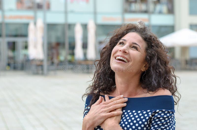 Dankbare jonge vrouw met haar handen aan haar hart royalty-vrije stock foto's Dankbare jonge vrouw met haar handen aan haar hart royalty-vrije stock foto's