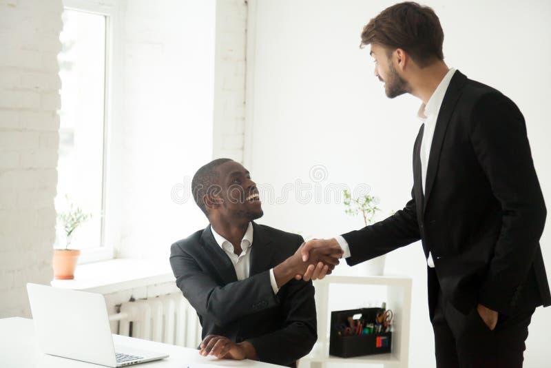 Dankbare Kaukasische uitvoerende congra van de handenschudden Afrikaanse werknemer stock afbeeldingen Dankbare Kaukasische uitvoerende congra van de handenschudden Afrikaanse werknemer stock afbeeldingen