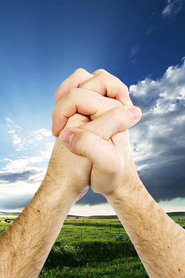 A pair of hands giving thanks on the prairie landscape. A pair of hands giving thanks on the prairie landscape