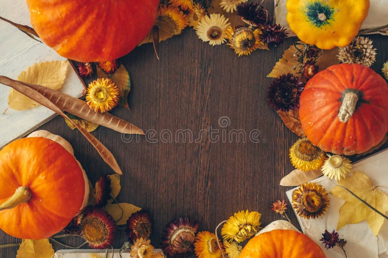Dankzeggingsachtergrond met de herfst droge bloemen, pompoenen en dalingsbladeren op de oude houten achtergrond Overvloedig oogst