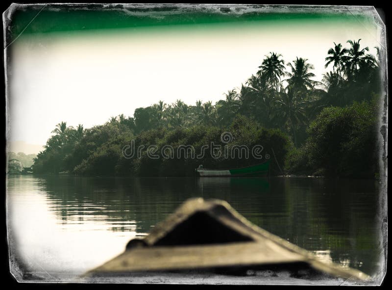 Dans le bateau indien nageant en bas de la carte postale b de vintage de rivière de jungle images libres de droits Dans le bateau indien nageant en bas de la carte postale b de vintage de rivière de jungle images libres de droits