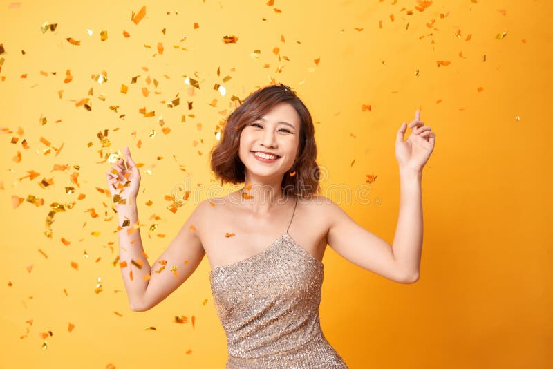 Danse de jeune femme sous des confettis ? la maison, c?l?brant l'anniversaire photos stock Danse de jeune femme sous des confettis ? la maison, c?l?brant l'anniversaire photos stock