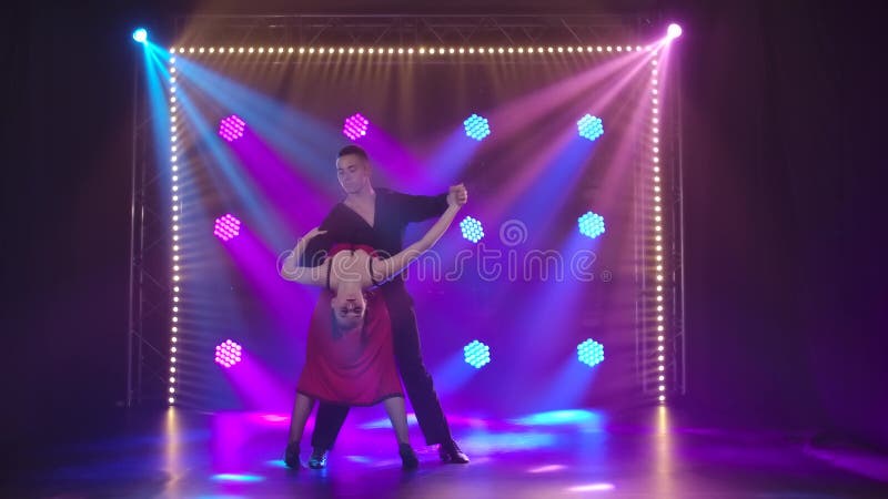 Danse passionnante de tango réalisée par un couple charmant Une femme en robe rouge ouverte avec une fente profonde et un homme e banque de vidéos