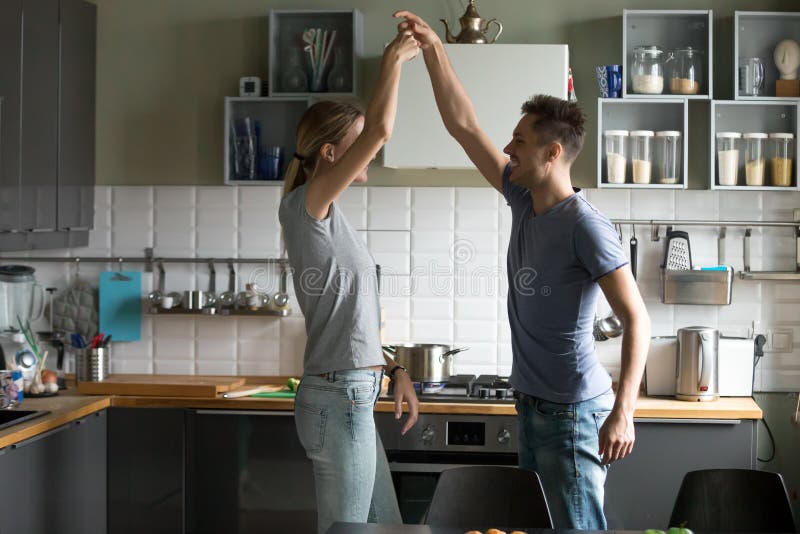 Danse romantique heureuse de couples dans la cuisine tout en faisant cuire le toget photo stock Danse romantique heureuse de couples dans la cuisine tout en faisant cuire le toget photo stock