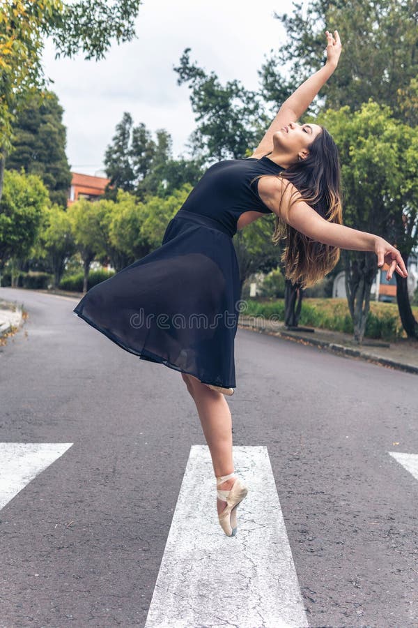 Latin female ballet dancer dancing on a crosswalk in the city. Latin female ballet dancer dancing on a crosswalk in the city