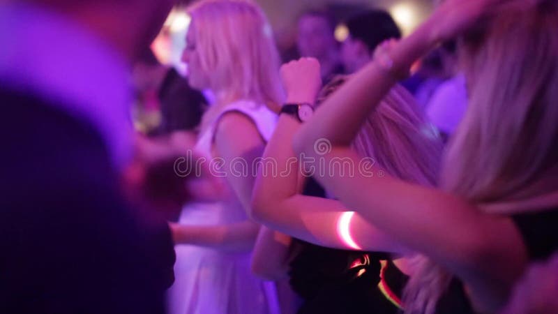 Dança da menina em um clube, em uma multidão de povos