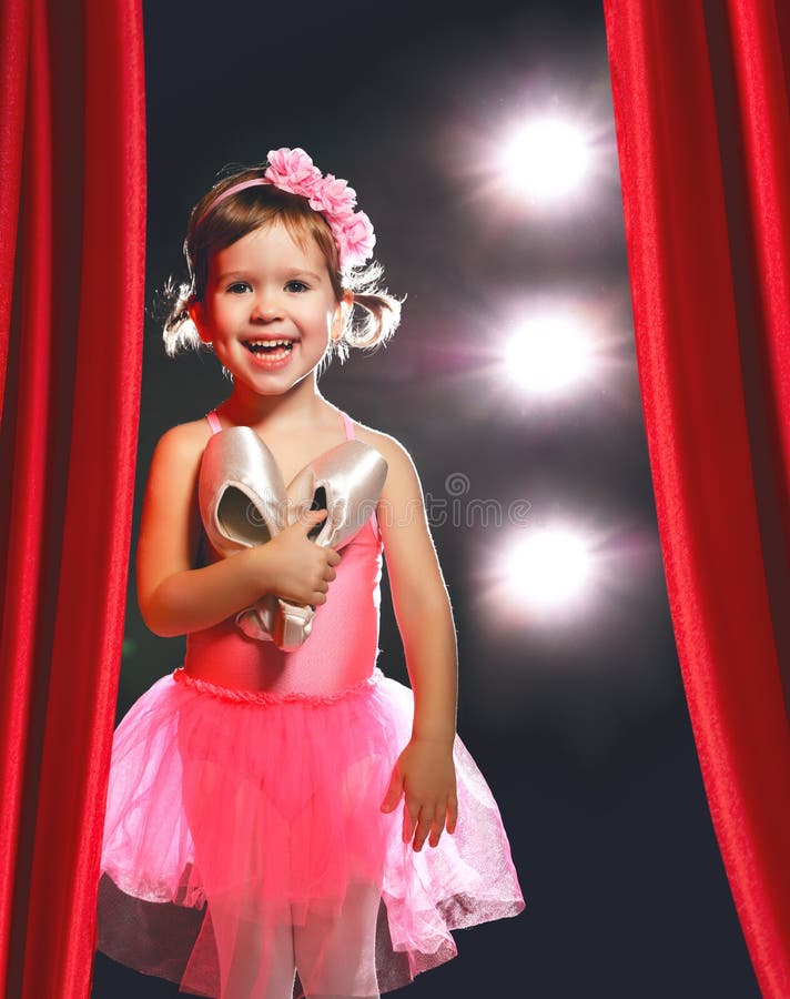 Dançarino de bailado da bailarina da menina na fase em cenas laterais vermelhas foto de stock Dançarino de bailado da bailarina da menina na fase em cenas laterais vermelhas foto de stock