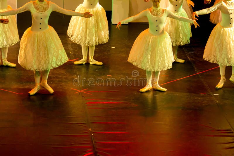 Dançarinos de bailado com os vestidos clássicos que executam um bailado no fundo do borrão imagem de stock Dançarinos de bailado com os vestidos clássicos que executam um bailado no fundo do borrão imagem de stock
