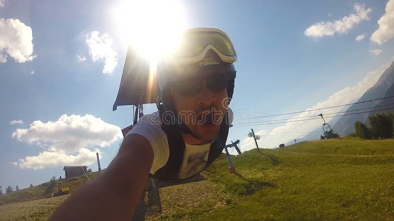 Daredevil guy descending zipline, filming his adventure on action camera