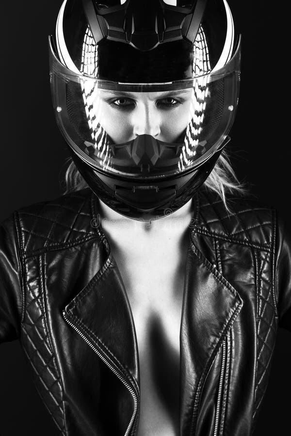 Daring girl model in black leather dress, style of rock on naked body, dark makeup and wet hair with amotorcycle helmet