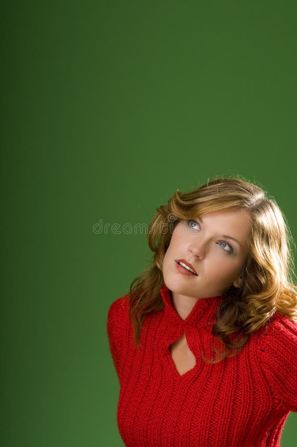 Dark blond woman looking up on green background