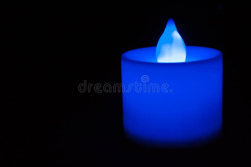 An Electric Candle Burning Under a Glass on Table Stock Photo Image