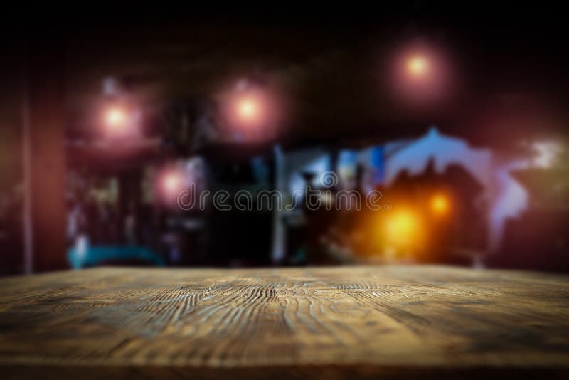 Dark Blurred Background Of Bar Restaurant And Old Brown Wooden Table Top With Space For Advertising Product.