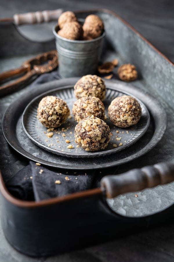 Dark Chocolate Truffle Coated in Chopped and Toasted Walnuts on a Plate