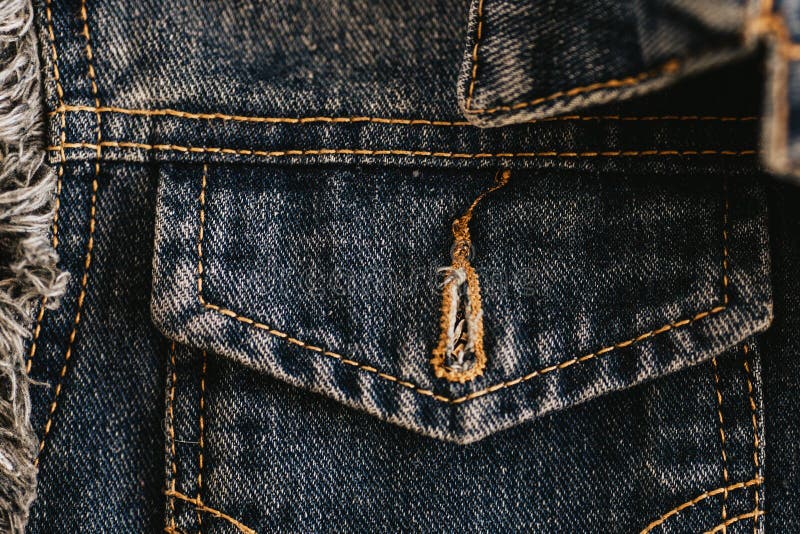 Dark-colored denim jacket pocket close-up. Denim with stitching and seam. stock images