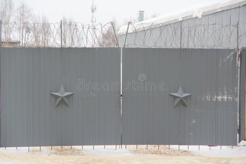 Dark gray walls with a five-pointed star and barbed wire