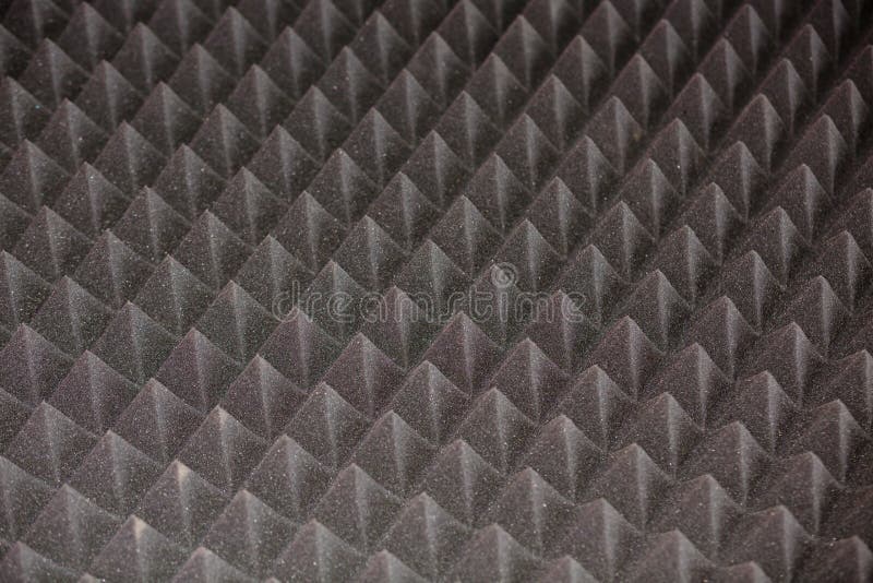Dark grey diamond-shaped soundproof coating with sharp pyramidal elements. Abstract geometric texture or background royalty free stock photo