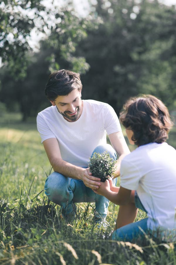 Dark-haired and his father holding the plant ready to plant it royalty free stock photo