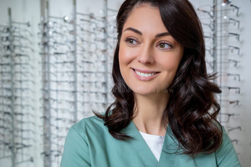 Dark-haired young female ophthalmologist in a optic shop stock image