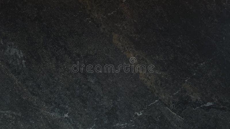 Dark natural background of textured marble wall. Close-up view