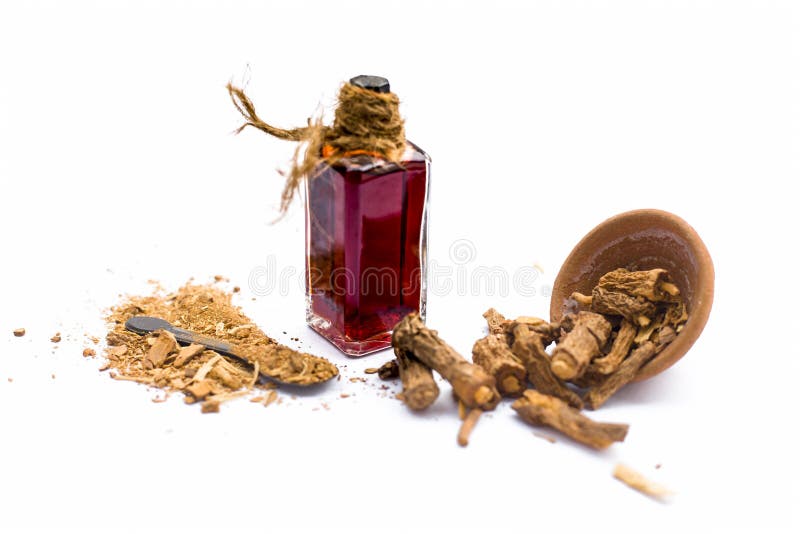 Dark red colored essence of nannari or Indian sarsaparilla in a transparent bottle isolated on white.