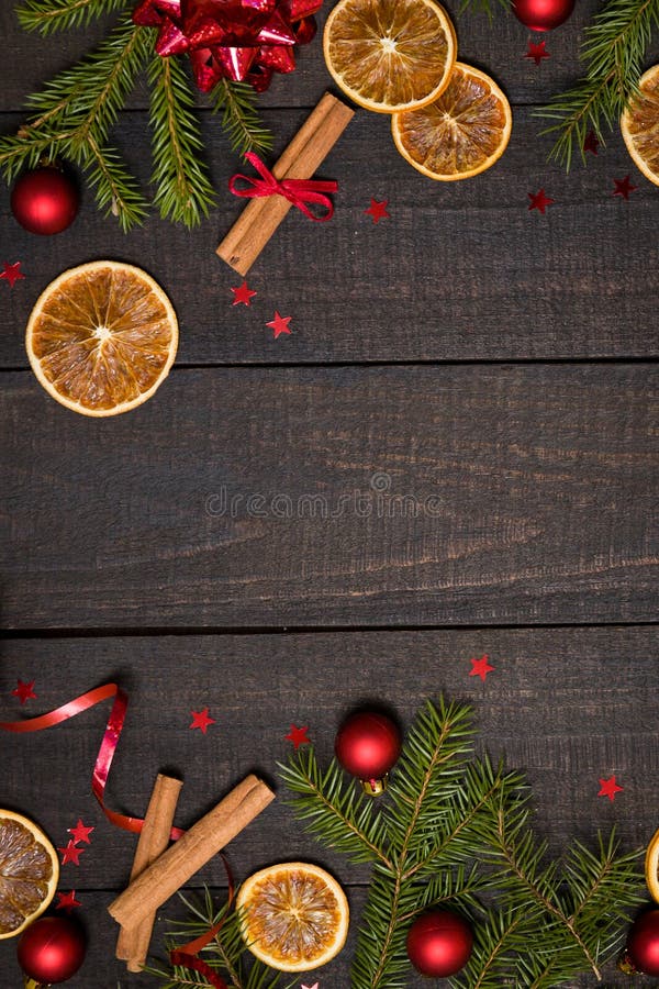 Dark rustic wood table flatlay - Christmas background with decoration and fir branch frame. Top view with free space for copy