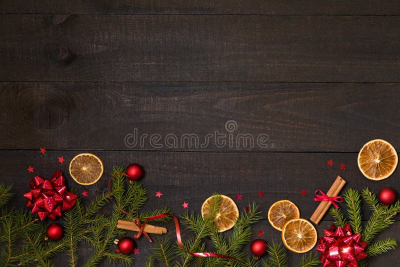 Dark rustic wood table flatlay - Christmas background with decoration and fir branch frame. Top view with free space for copy