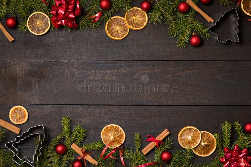 Dark rustic wood table flatlay - Christmas background with decoration and fir branch frame. Top view with free space for copy