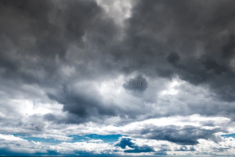 The dark sky with heavy clouds converging and a violent storm before the rain. Bad or moody weather sky and environment stock photo