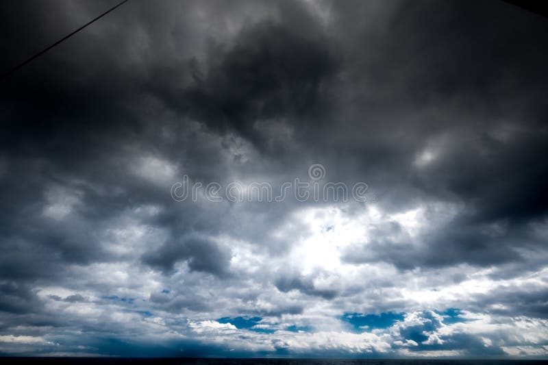 The dark sky with heavy clouds converging and a violent storm before the rain. Bad or moody weather sky and environment stock photography