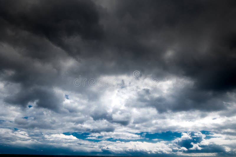 The dark sky with heavy clouds converging and a violent storm before the rain. Bad or moody weather sky and environment stock images