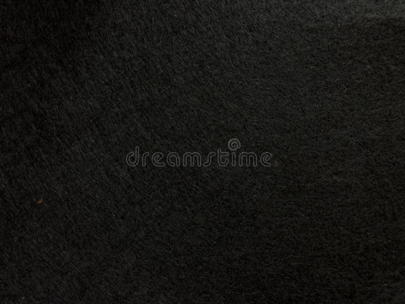 Dark textured surface background with subtle patterns and shadows