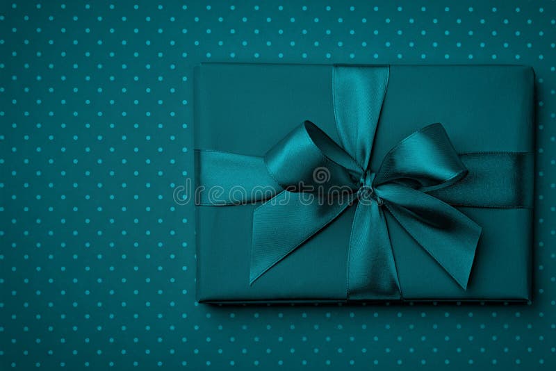 Dark turquoise gift box flat lay on dark turquoise background. Concept present box decoration holiday top view. Copy Space stock photography