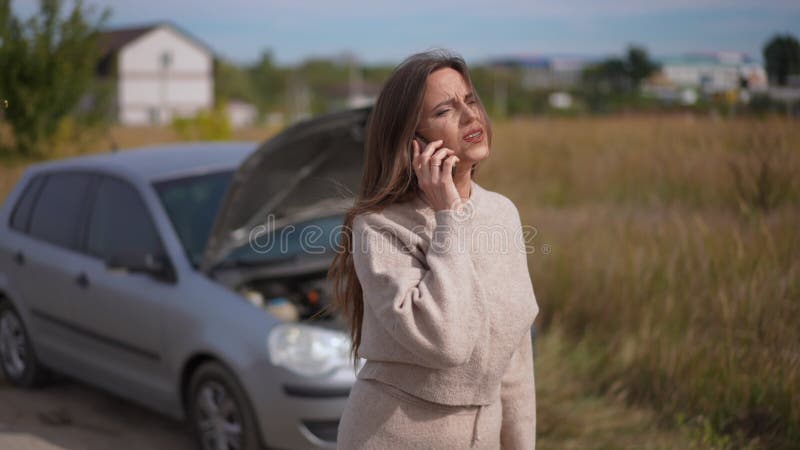 Darstellung der besorgten Frau, die auf der Vorstadtstraße in einem kaputten Auto eine Versicherung anruft. sorgsam