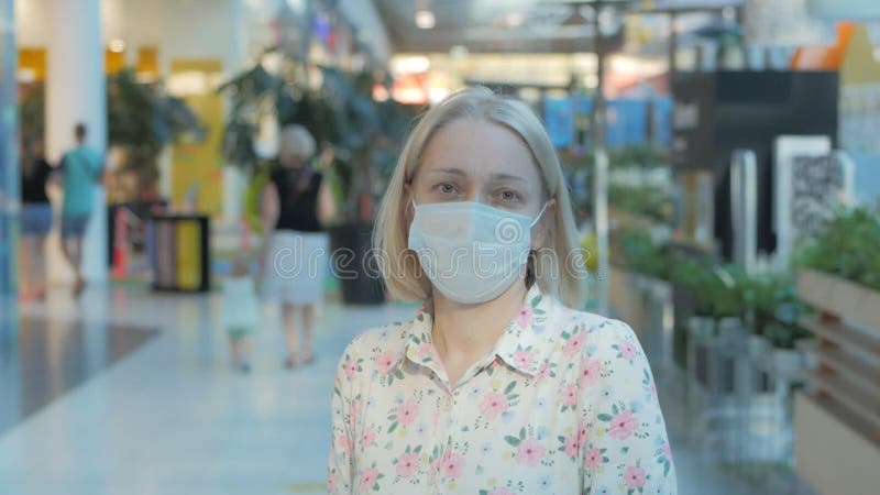 Darstellung einer Maskenfrau in einem Einkaufszentrum.