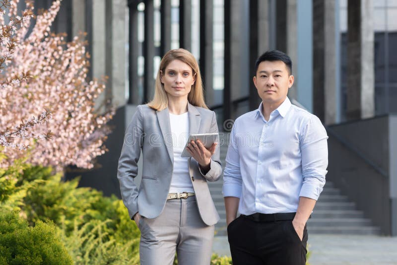 Darstellung zweier interrassischer Geschäftsleute. eine junge Frau und ein junger asiatischer Mann in der Nähe des Büros lizenzfreie stockfotografie