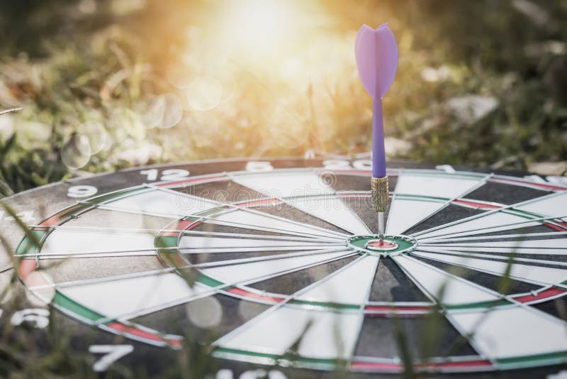 Dart on board on grass background, concept as success and goal stock photo Dart on board on grass background, concept as success and goal stock photo